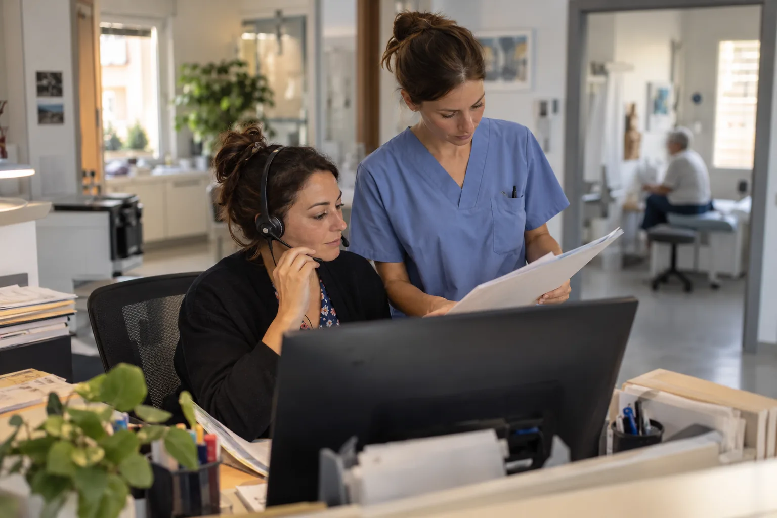 Medewerker patiëntservice en verpleegkundige bespreken een opvolggesprek in een Europese polikliniek