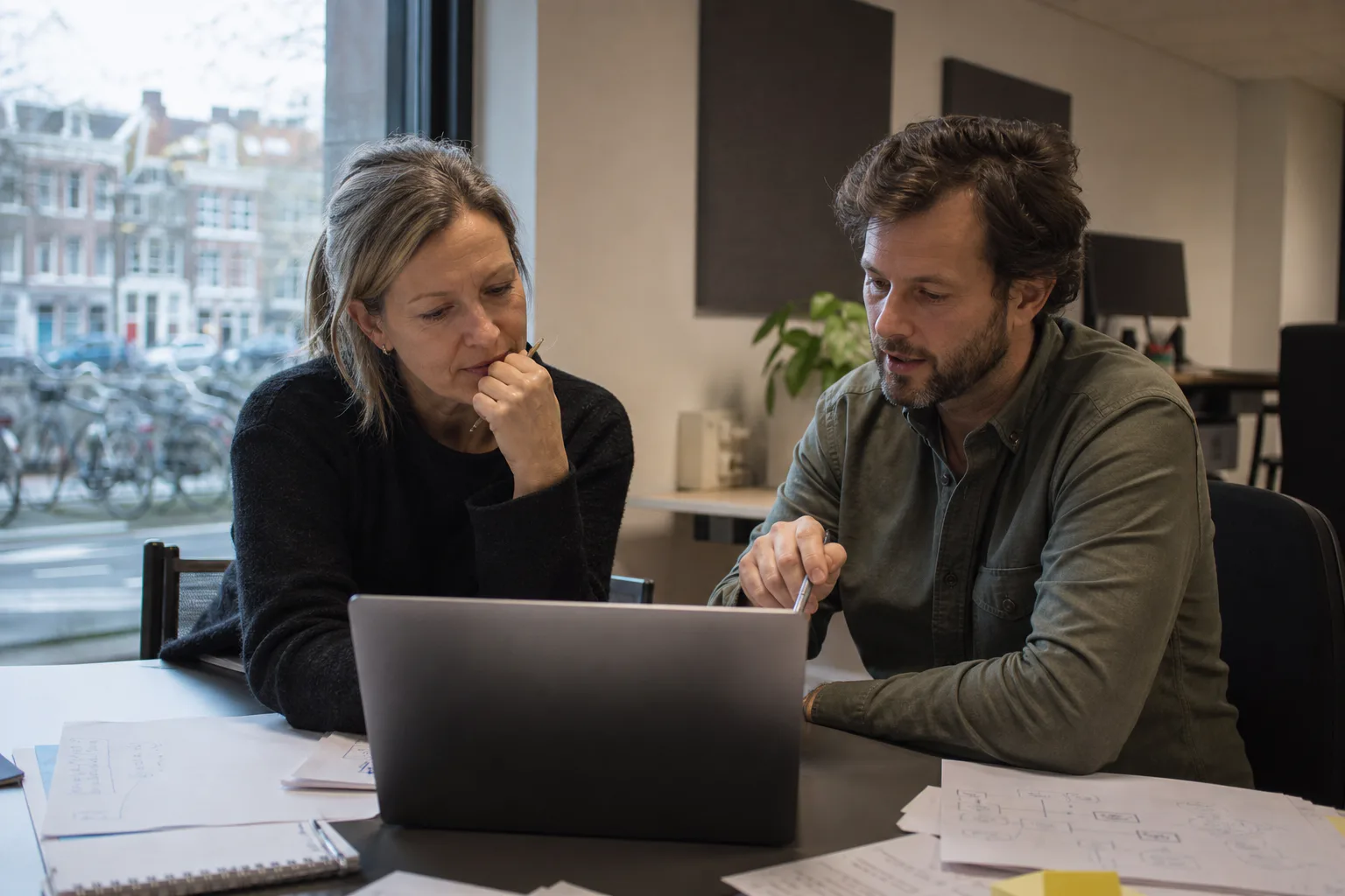 Operationsleiterin und Niederlassungskoordinator prüfen das Angebot eines Voice-AI-Anbieters in einem europäischen Büro